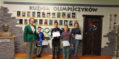 Powiększ grafikę: Zdjęcie uczestników konkursu z dyrektor szkoły ZSSiMS Ewą Leyk-Latowską na tle Kuźni Olimpijczyków.
